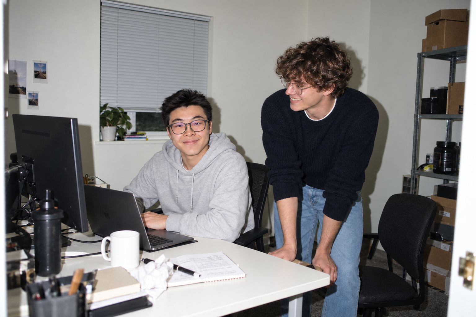 An AI-generated scene of Forrest and Sam working together at a laptop in a small, everyday office
