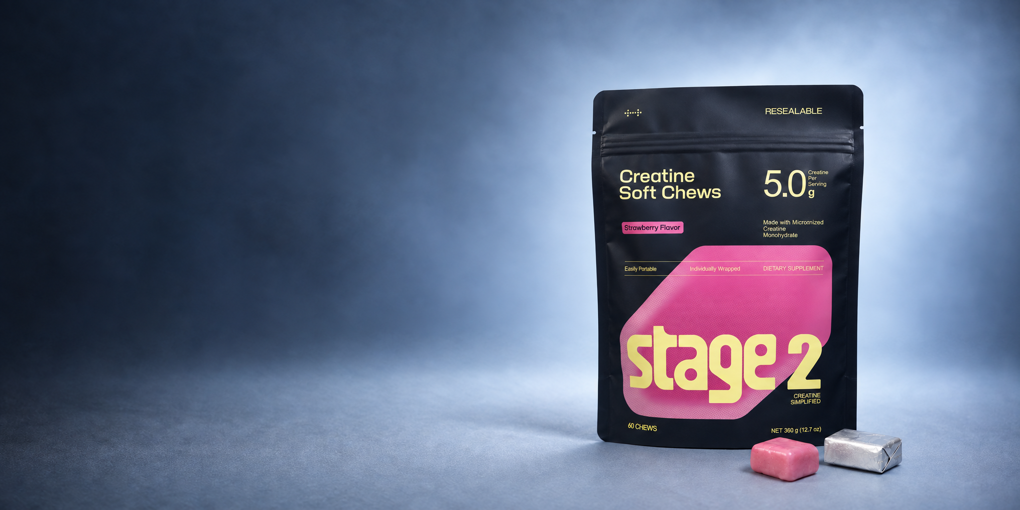 Stage 2 strawberry creatine soft chews pouch with one unwrapped pink chew and one silver foil-wrapped chew in a layered smoky blue studio