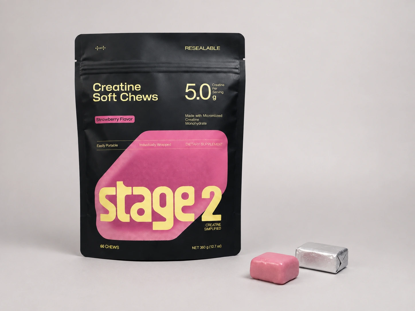 Stage 2 strawberry creatine soft chews pouch with one unwrapped pink chew and one similarly shaped silver foil-wrapped chew